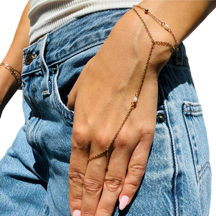hand wearing hand chain with pearls 